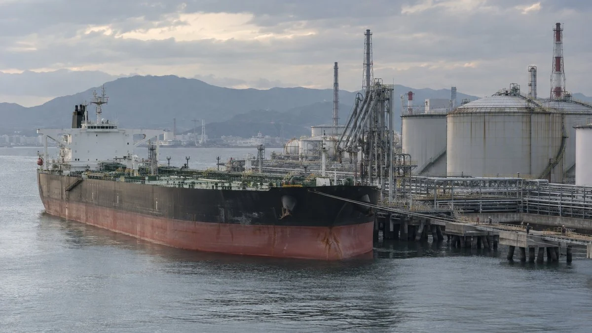 製油所の桟橋に接岸した原油タンカーと貯蔵タンク