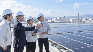 工場の屋上で太陽光パネルを見渡す技術者と管理職