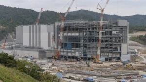 丘陵地の工業団地で建設が進む大型工場棟とクレーン