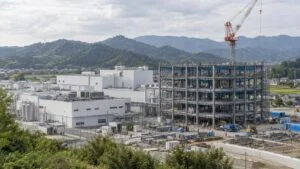 既存の医薬品工場の隣で鉄骨を組む新工場の建設現場