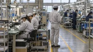 通路で区切られた2つの作業エリアで組立作業をする工場の様子