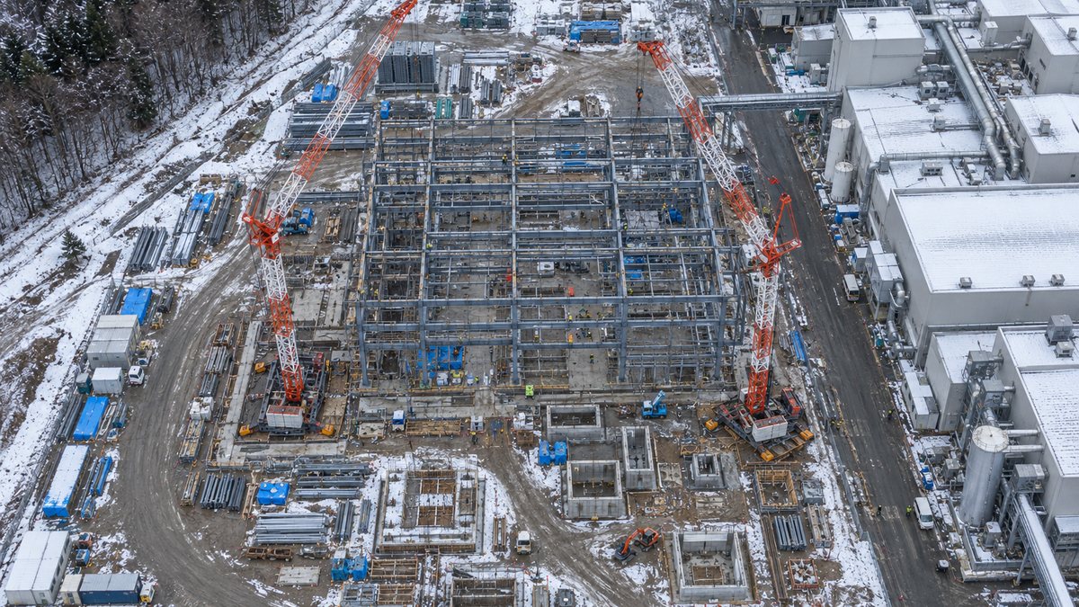 雪の残る工場敷地で鉄骨を組む建設現場の空撮