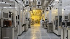 半導体工場のクリーンルームに並ぶ前工程の製造装置と天井の搬送レール